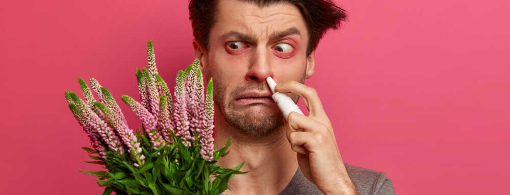 Hay fever sufferer holding flowers