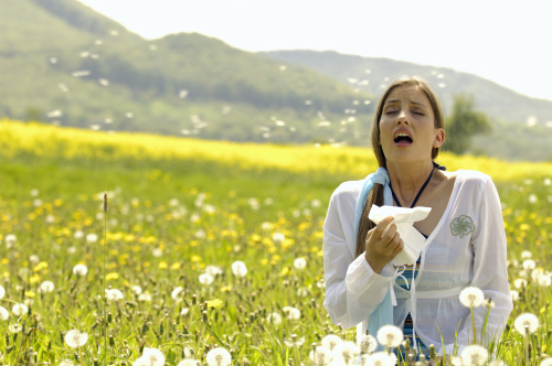 Woman sneezing into a hanky - hay fever
