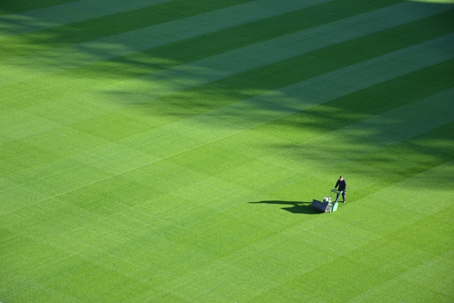 Man mowing a huge lawn with a mower