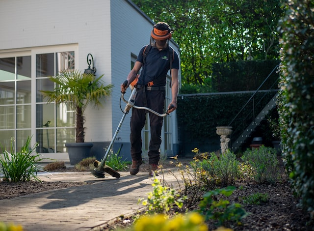 A man holding an electric power strimmer