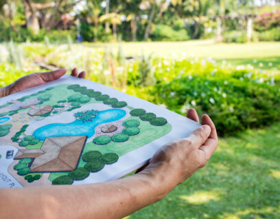 A person holding a garden design on a sheet of paper.
