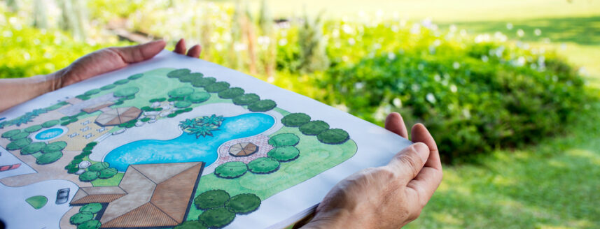 A person holding a garden design on a sheet of paper.