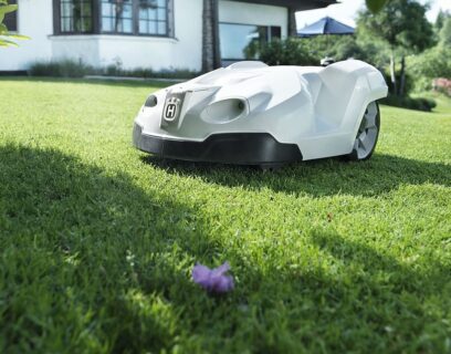 White car-like robot lawnmower on grass
