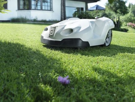 White car-like robot lawnmower on grass