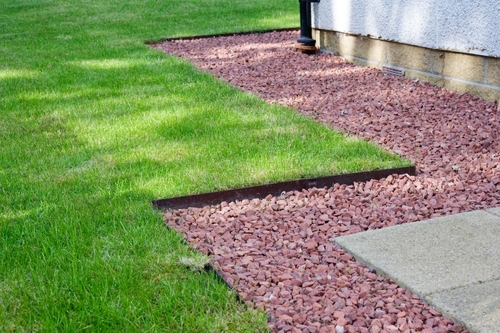 A strip of gravel between a lawn and a house