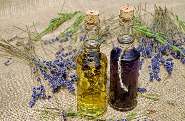 Lavender oils in two bottles with sprigs on lavender on a hessian cloth. 