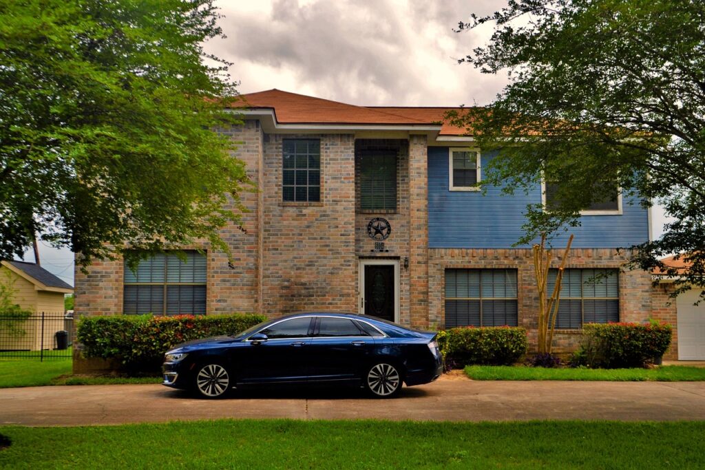 A car parked in front of a New England-style home