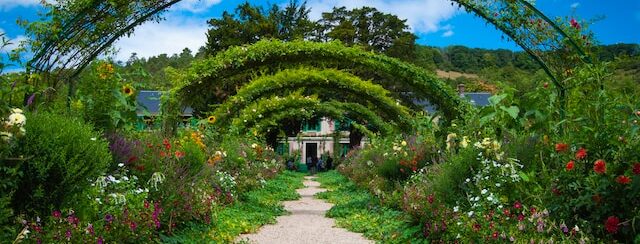 A lovely south-facing garden with green arches along a path