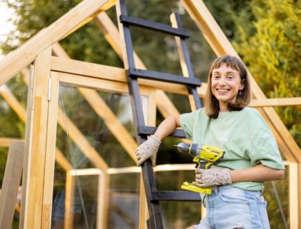 Woman constructing a DIY greenhouse