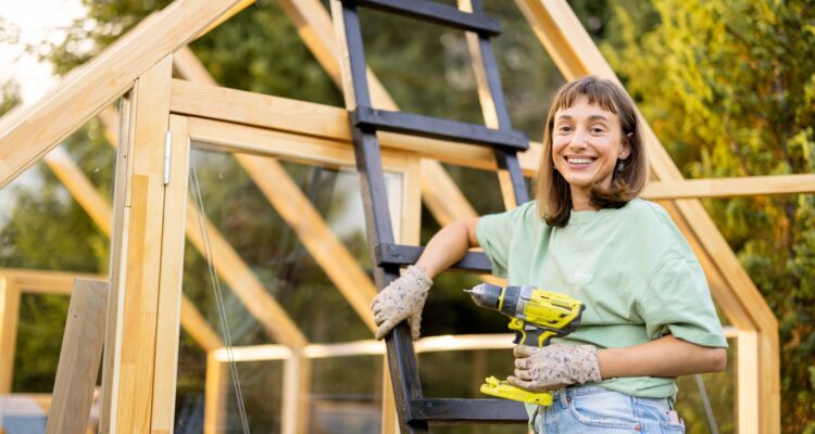 Woman constructing a DIY greenhouse